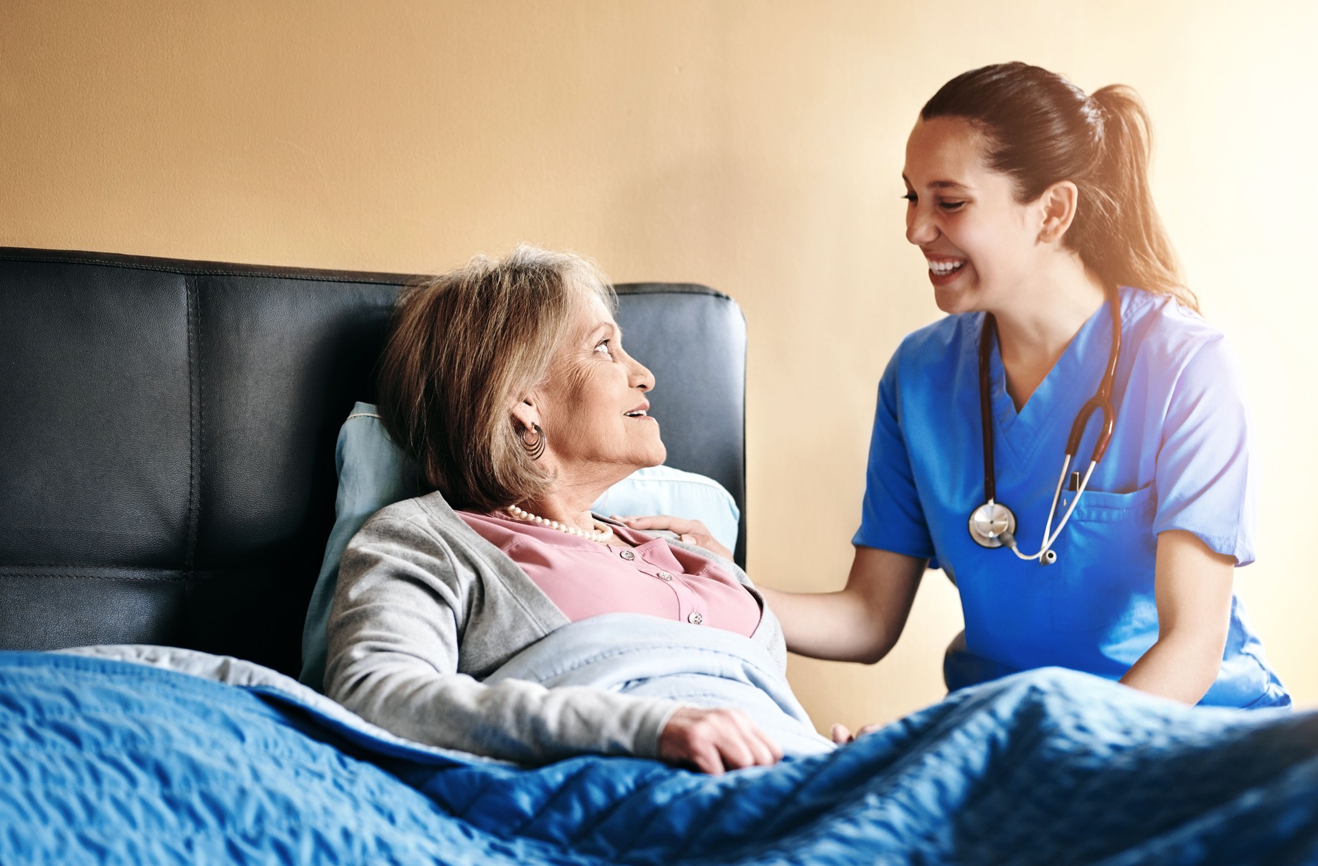 Assisted living, bedroom or retirement with nurse and old woman in home for private healthcare. Medical, smile and support with senior patient or resident with medicine professional in apartment
