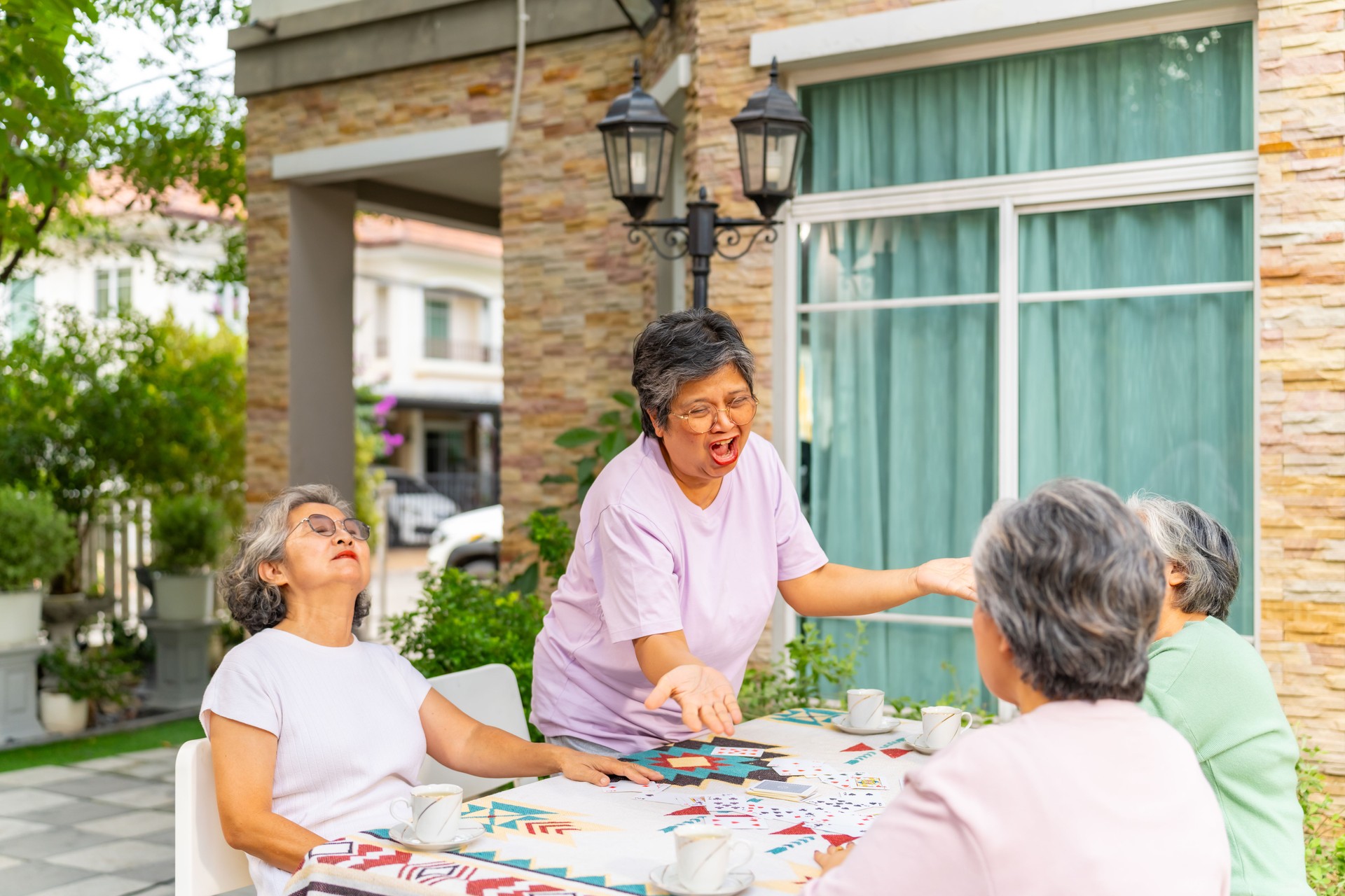Group of Elderly woman playing card game together at home.